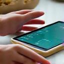 A person reviewing health data on a tablet next to a handcrafted ceramic bowl, symbolizing optimization