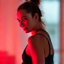 Jessica, an active woman, stretching after a run with a subtle glow on her leg from a red light device