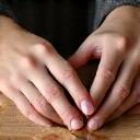 Close-up of hands gently working with clay on a pottery wheel, emphasizing tactile creativity and focus.